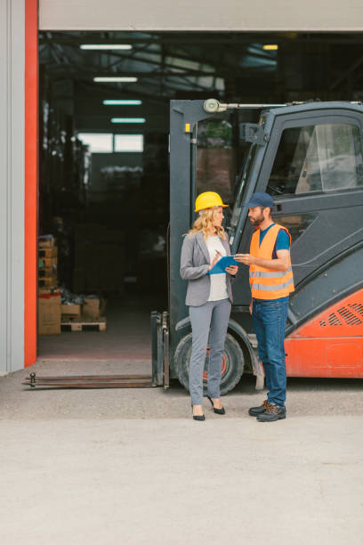 istock Manager and manual worker by the forklift in warehouse 682493064