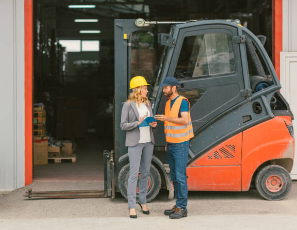 istock Manager and manual worker by the forklift in warehouse 682493216
