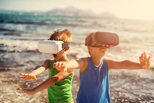 Unga killar med VR-glasögon på sandstrand