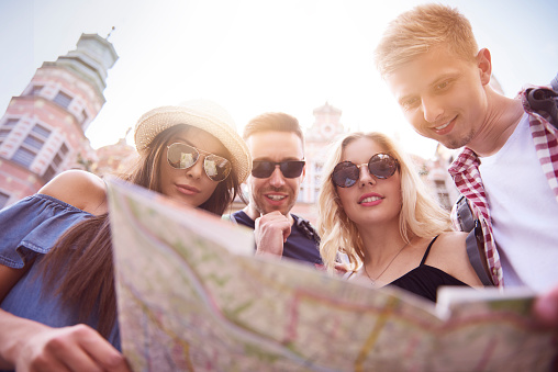 Low angle view of tourists with paper map