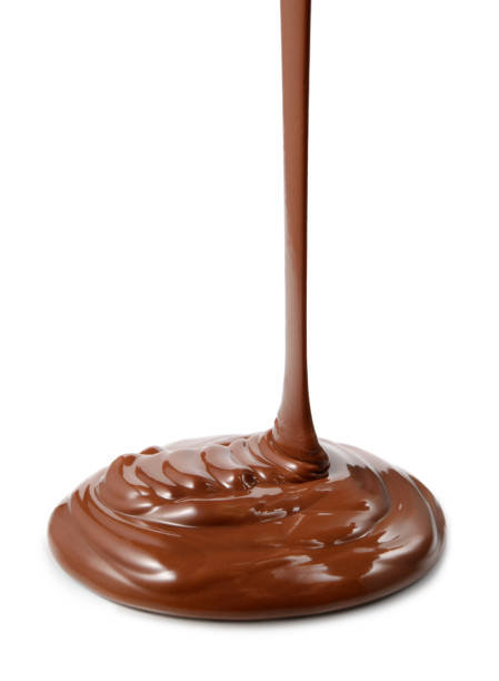 шоколадный поток изолированы на белом фоне крупным планом - chocolate topping стоковые фото и изображения