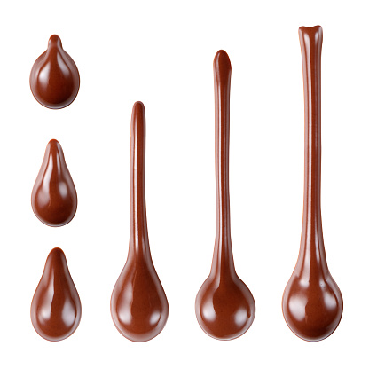 Melted hot chocolate syrup is dripping. Streams with drops isolated on white. With clipping path.