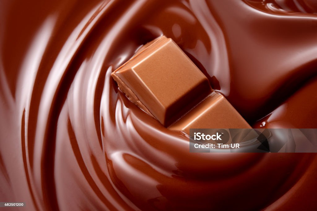 Geschmolzene Schokolade mit Schokoladenstückchen heiße Flüssigkeit. Hintergrund. - Lizenzfrei Vollmilchschokolade Stock-Foto