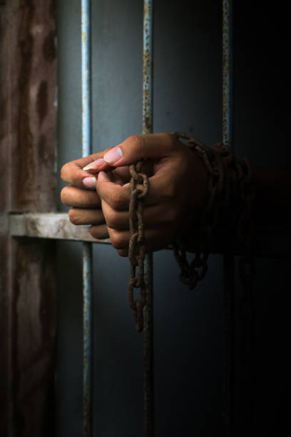 istock Prisoner with chain holding prison bar 682509524