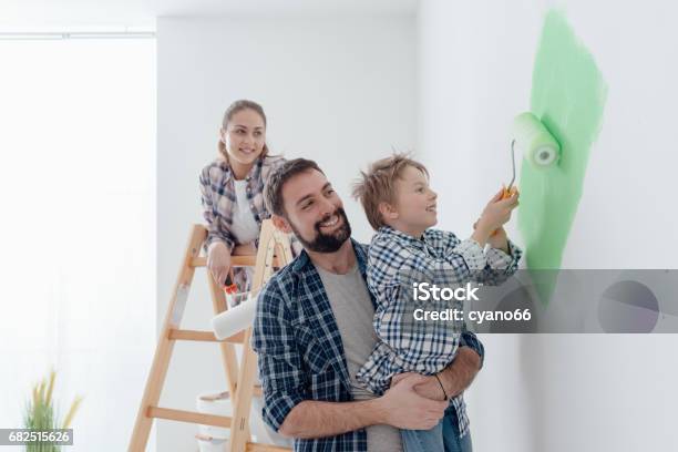 Family Painting A Room Together Stock Photo - Download Image Now - Family, Painting - Activity, House