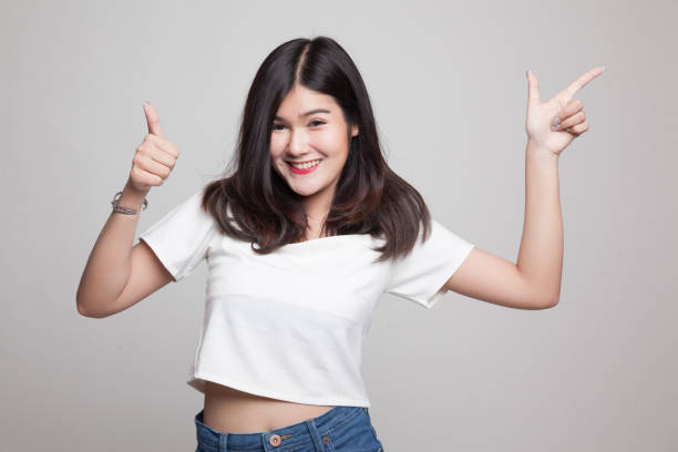 istock Young Asian woman point and thumbs up. 682517984