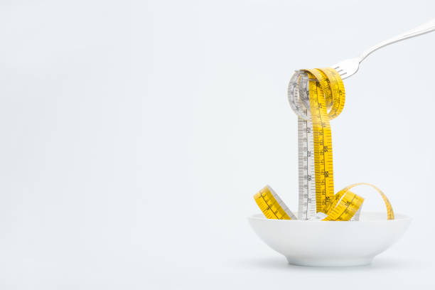 istock measuring tape on fork isolated on white, healthy living concept 682520908