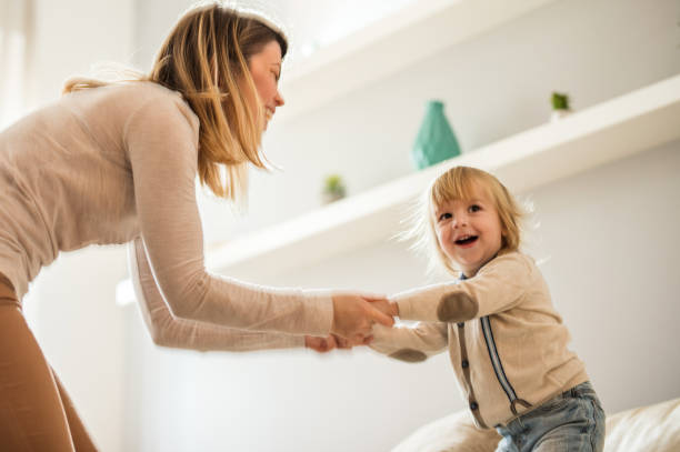 istock Joyful mother and son having fun while holding hands at home. 682528262