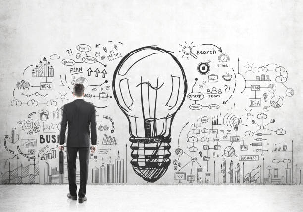 istock Man with suitcase looking at large bulb icon 682532558