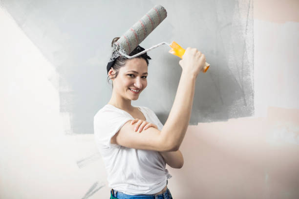 istock Young woman painting walls 682535896