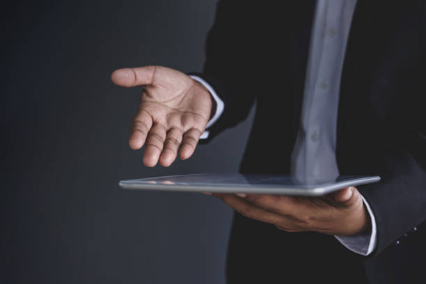 istock Businessman open hand to present digital tablet 682536324