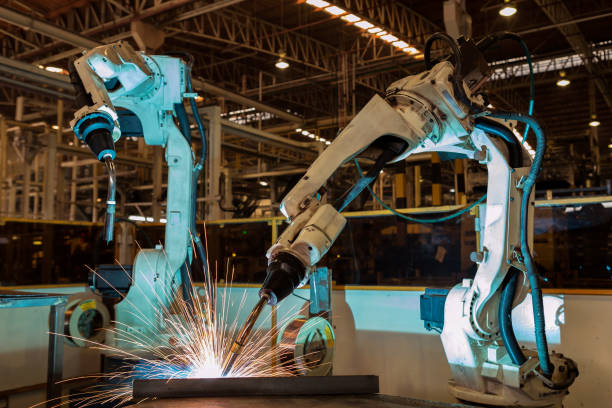 Team robots are welding assembly  part in factory