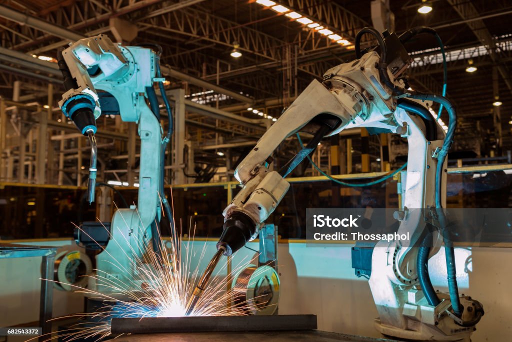 Team robots are welding assembly  part in factory Machinery Stock Photo