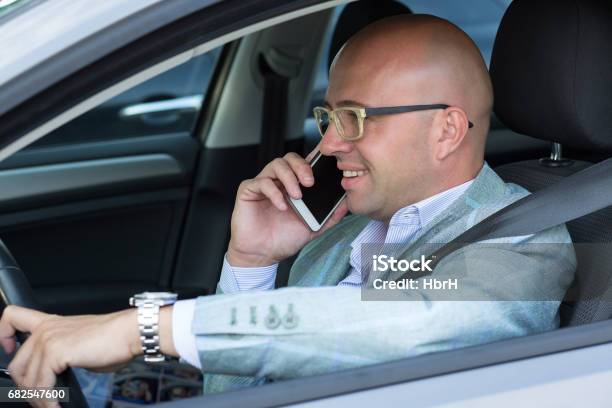 Side View Handsome Successful Young Man Smiling Talking On Mobile Phone While Driving His Car Risky Reckless Driver Bad Habits Traffic Safety Rule Violation Lack Of Attention Concept Stock Photo - Download Image Now