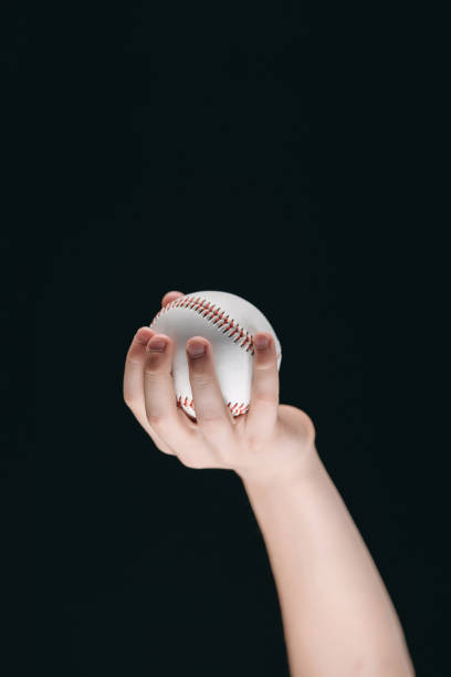 istock partial view of kid holding baseball ball isolated on black 682551230