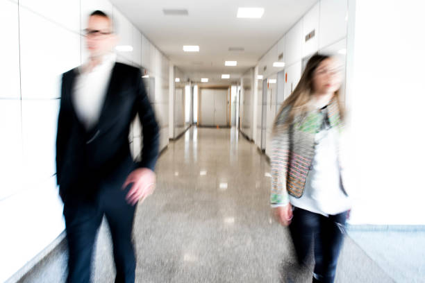 istock Blurred motion of two walking persons in a hall 682551306