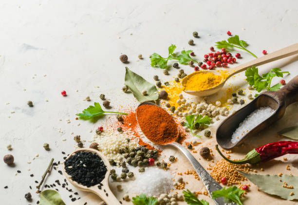 istock Spices in different spoons on a stone white background. A scattering of spices. 682554828