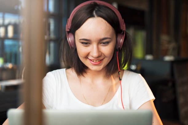 istock Young woman using laptop and headphones 682559360