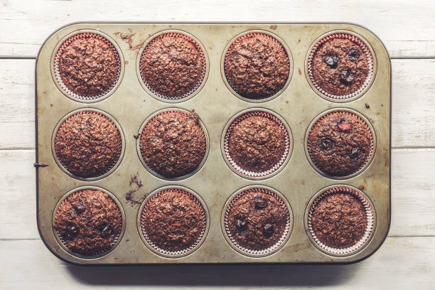 Chocolate bran muffins with cherries, in old, grunge looking, tin tray
