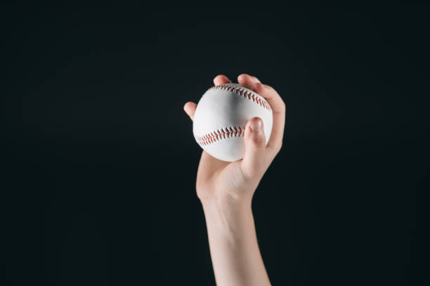 istock partial view of kid holding baseball ball isolated on black 682578858