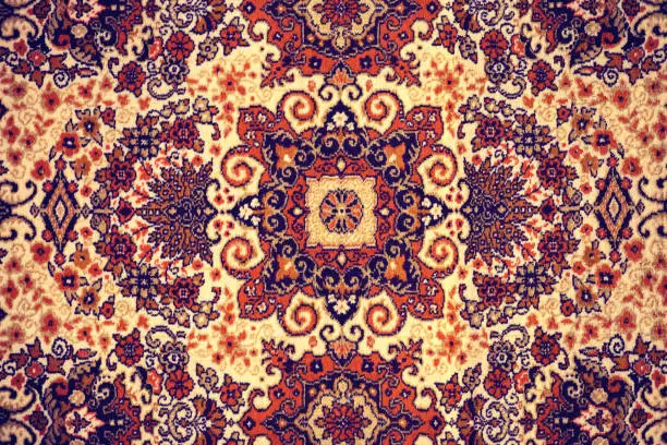 Photo of Persian Carpet. Closeup of national popular antique oriental backdrop, beautiful artistic, texture. Abstract repeating design of red blue flower on yellow color style background wallpaper texture.