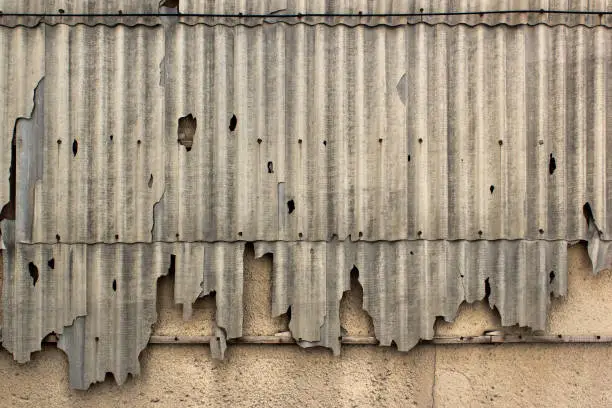 Photo of Old broken slate panels on a wall.