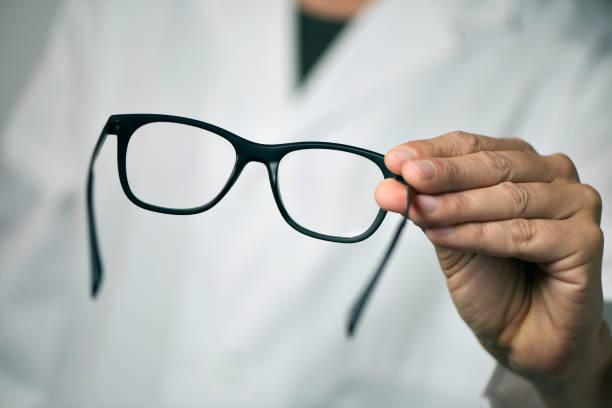 istock optician man bringing a pair of eyeglasses 682585614