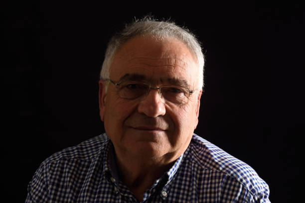 istock Portrait of a senior man with black background 682585820