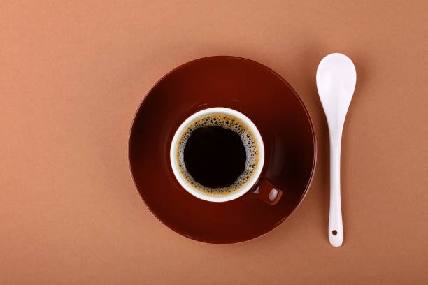 istock Full small brown cup of black coffee on parchment 682589758