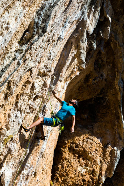 istock Rock Climber hanging on one hand high over the deep 682614216