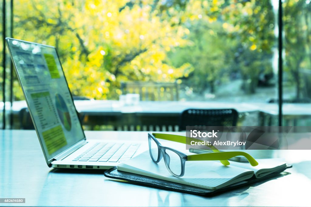 Internet Project Work at cozy Summer Location Internet Project Work on Laptop Computer staying on black wood Table situated in open space cozy Office or Home with sunny Garden outside Window Environmental Conservation Stock Photo