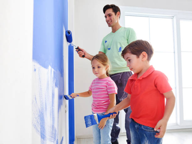 istock Father and kids painting wall 682614908