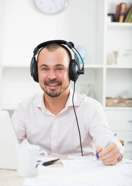 istock Positive man in headphones near computer 682628706