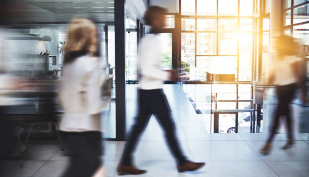 Success is connected with action so keep moving Shot of businesspeople walking in a busy office obscured face stock pictures, royalty-free photos & images