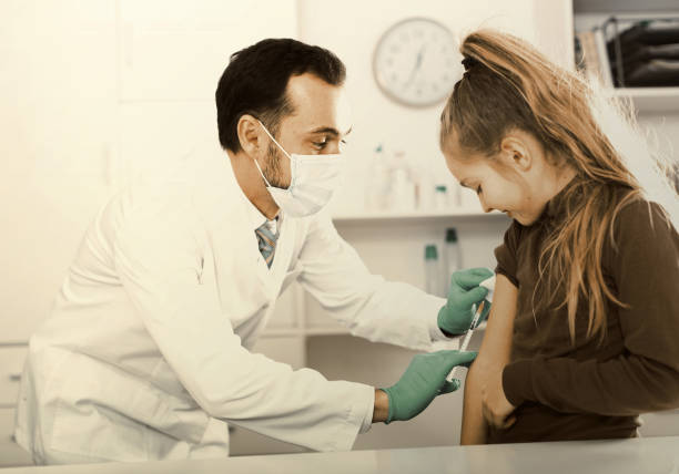 istock Male doctor injecting little patient 682631908