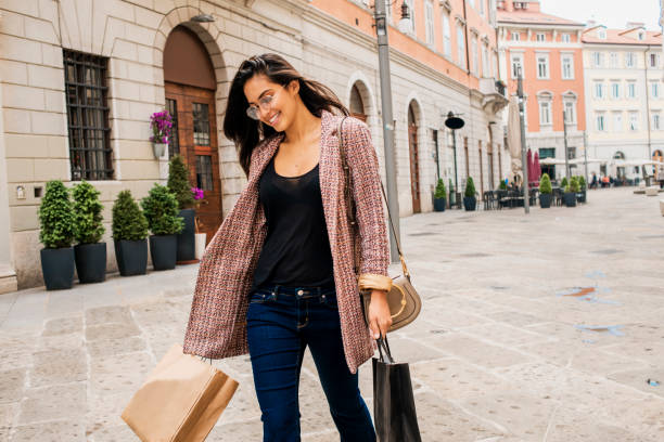 beautiful young woman carrying shopping bags beautiful young woman walking in the city after shopping blazer jacket stock pictures, royalty-free photos & images