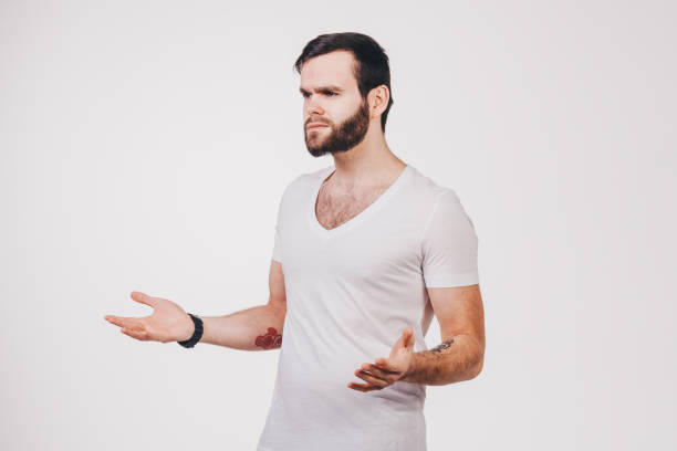 istock unshaved man in white t-shirt with tattoo thoughtful 682640738