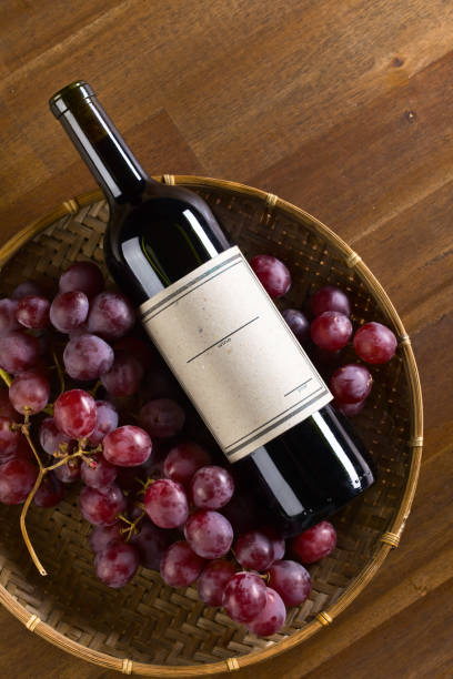 istock Bottle of red wine and grape on old wooden table 682655412