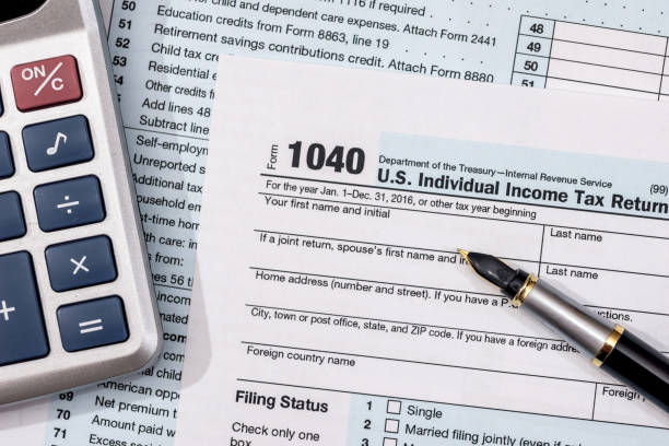 U.S. 1040 tax form with pen and calculator.