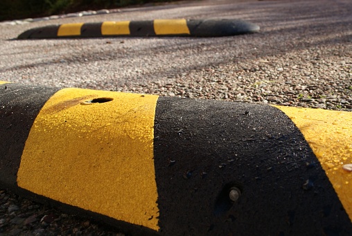 Speedbumps on a sunny morning. Placed on pavement to slow down speed of motorbikes, mopeds, cars and bicycles.