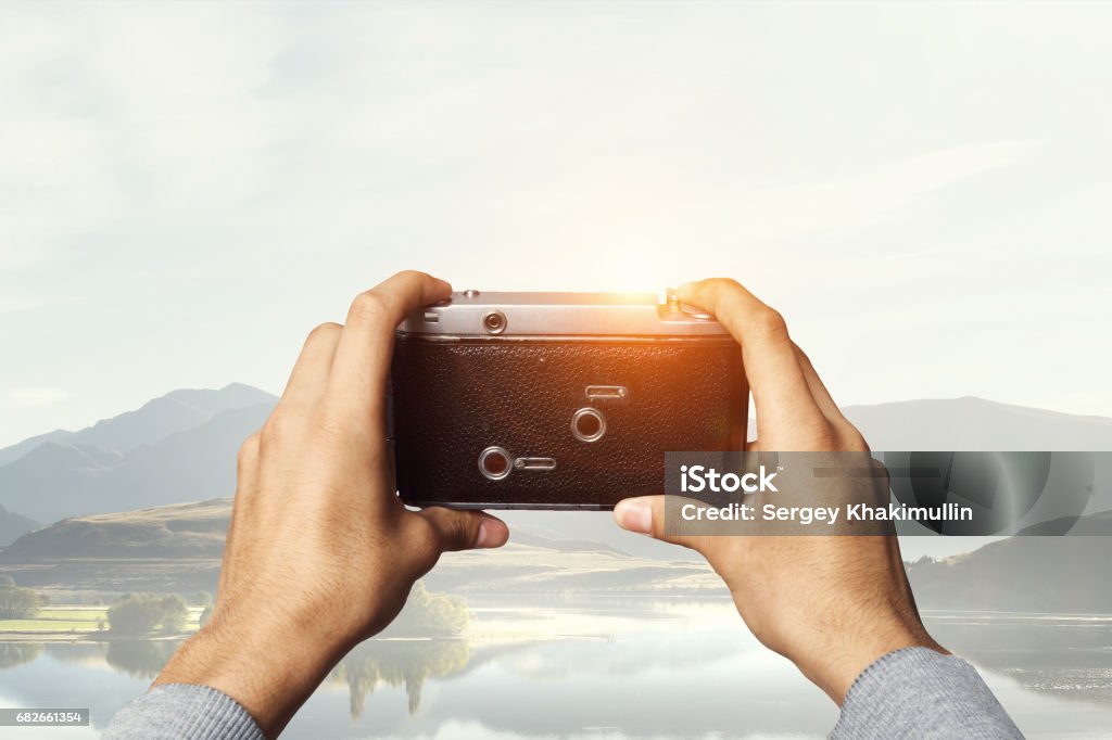 Man with camera in hands Close view of man taking photo with vintage camera Adult Stock Photo