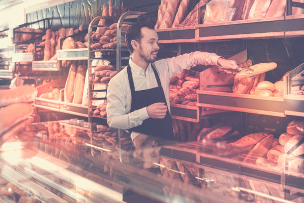 istock Seller offering fresh loaf of bread 682668092