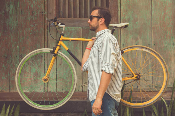 hipster uomo con vecchia bicicletta. - racing bicycle bicycle cycling yellow foto e immagini stock