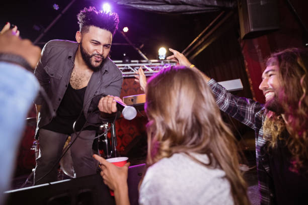 istock Male singer holding mic by female fan during performance 682683038