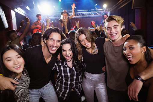 Portrait of cheerful friends enjoying at nightclub during music festival