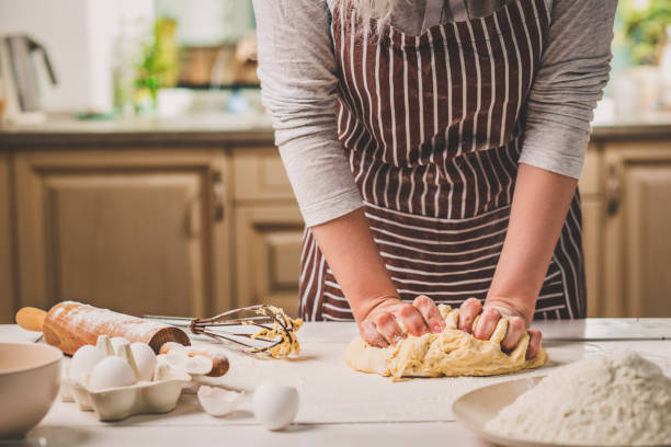 istock Woman hands kneading dough on kitchen table 682692536