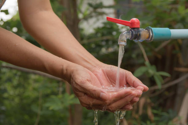 water pouring in woman hand on nature background. - water human hand stream clean imagens e fotografias de stock