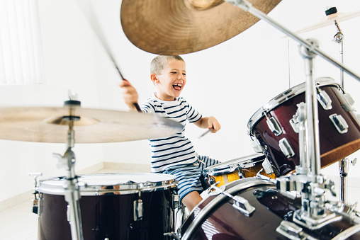 Determined little boy learning how to play drums