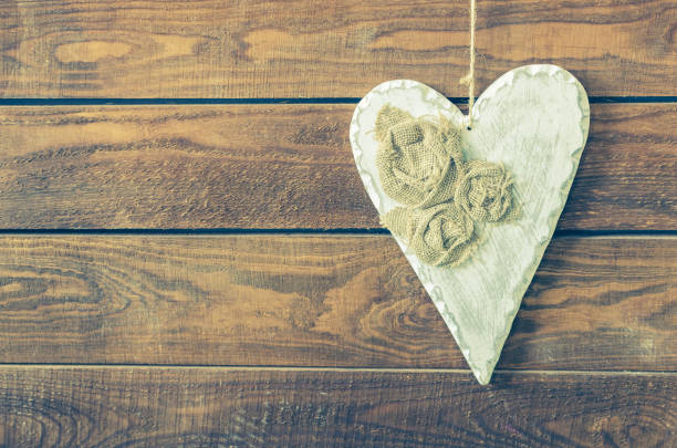 istock White heart on a rustic wooden background. 682697540