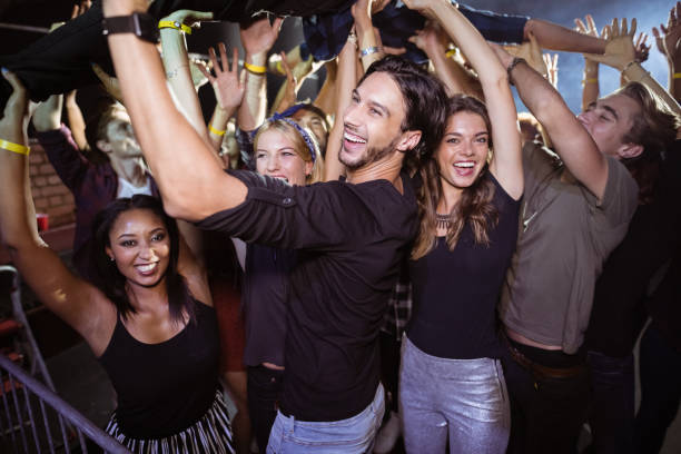 istock Cheerful crowd lifting performer at nightclub 682703504